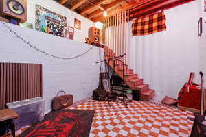 Basement featuring stairs and concrete block wall