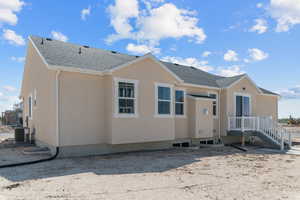 Rear view of property with stucco siding and a shingled roof
