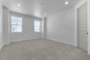 Spare room featuring light carpet and recessed lighting