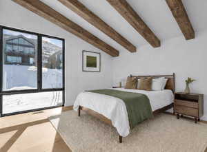 Bedroom featuring vaulted ceiling with beams and light wood-type flooring