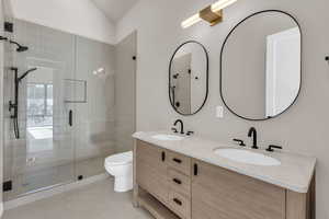 Bathroom featuring double vanity, a shower stall, and light tile patterned floors
