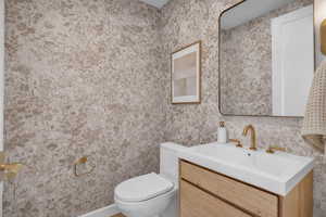Bathroom featuring vanity and wallpapered walls