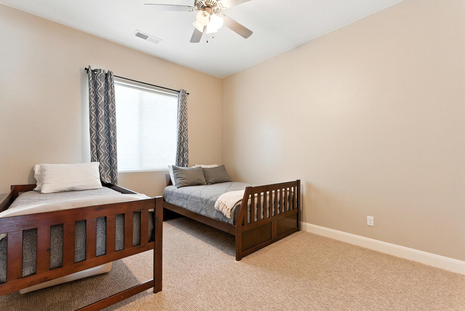 Bedroom with ceiling fan and light colored carpet