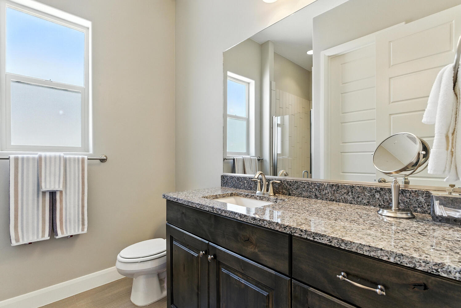 Full bathroom featuring a shower stall, vanity, and light wood finished floors