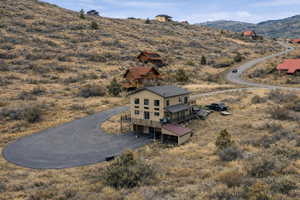Aerial view of property and surrounding area with a mountain backdrop
