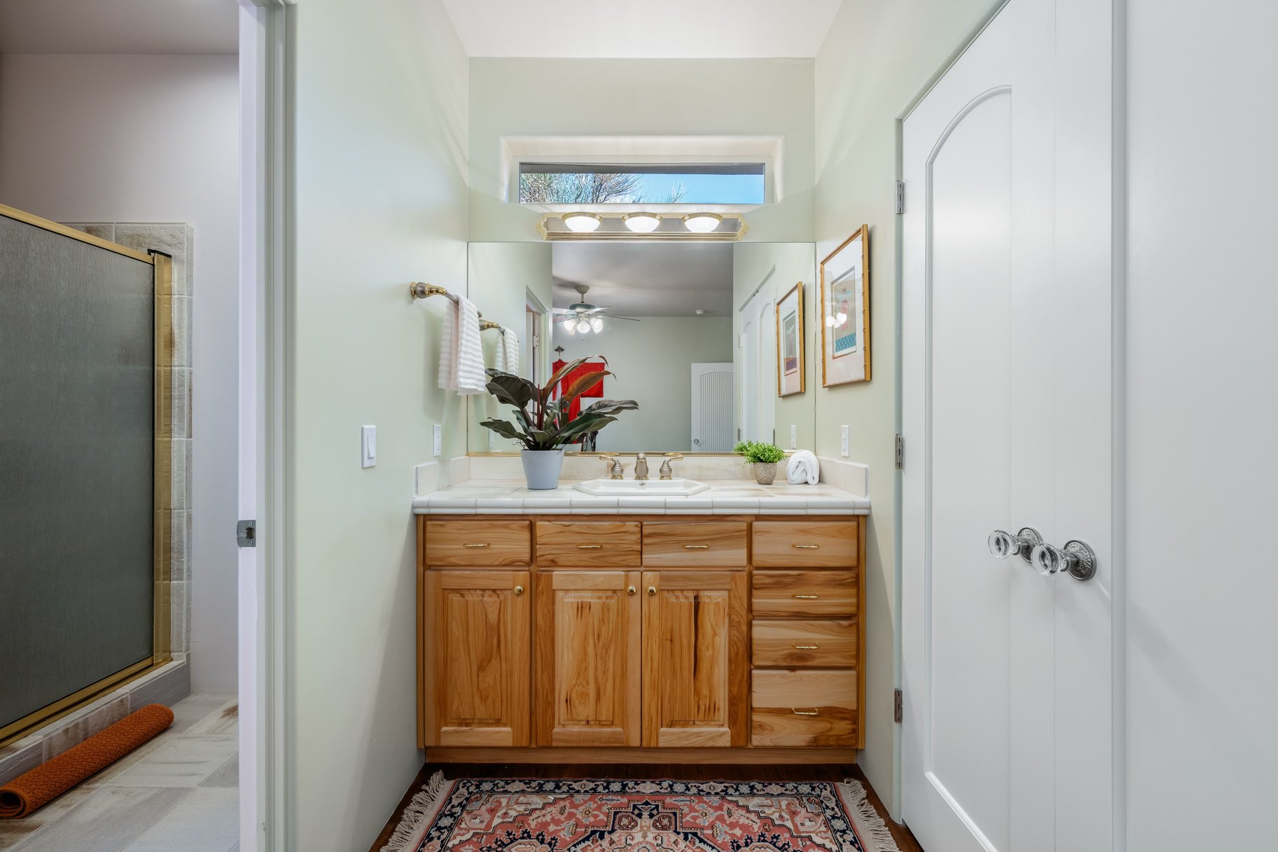 Full bath featuring vanity, a shower stall, and a ceiling fan