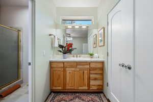 Full bath featuring vanity, a shower stall, and a ceiling fan
