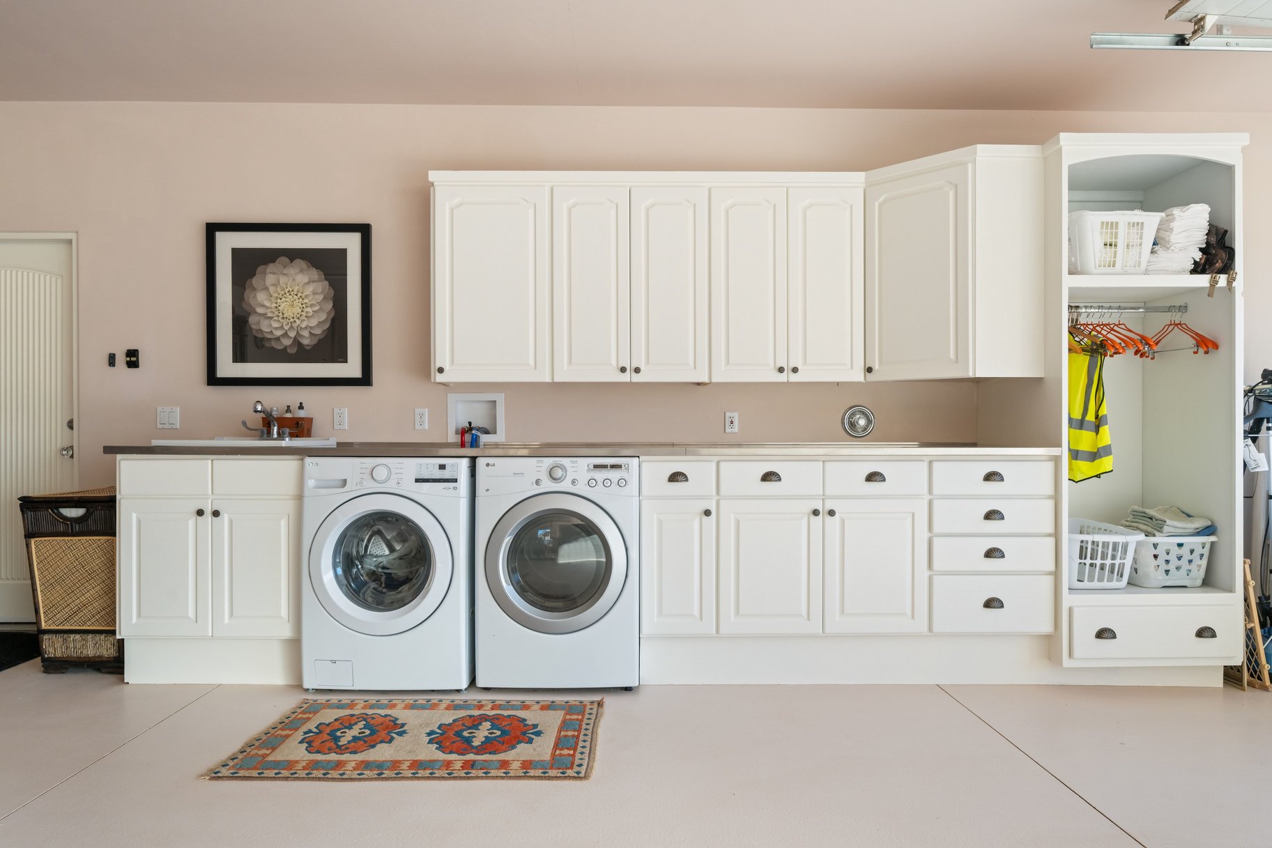 Laundry room with washer and dryer, cabinet space, and finished concrete floors