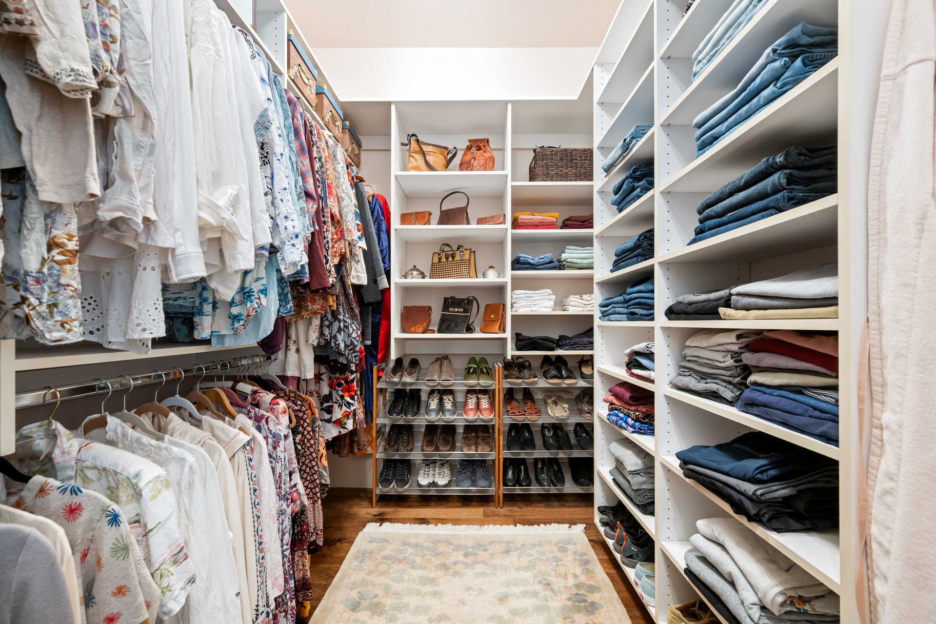 Walk in closet with dark wood-type flooring