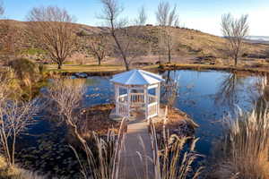 Dock featuring a water and mountain view and a gazebo