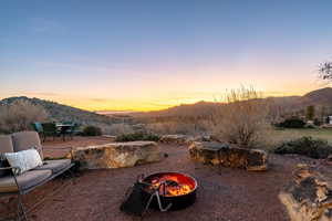 View of yard with a mountain view, an outdoor fire pit, a patio area, and outdoor dining area