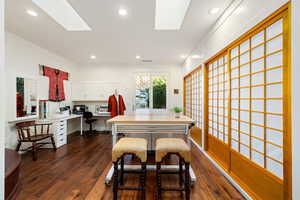 Dining room with dark wood-type flooring, recessed lighting, a skylight, and built in desk