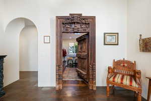 Hallway featuring arched walkways and dark stone finish floors