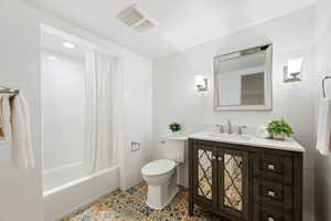 Full bath featuring shower / bath combo with shower curtain, vanity, tile walls, and tile patterned flooring