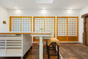 Dining room with dark wood-type flooring, recessed lighting, and a skylight