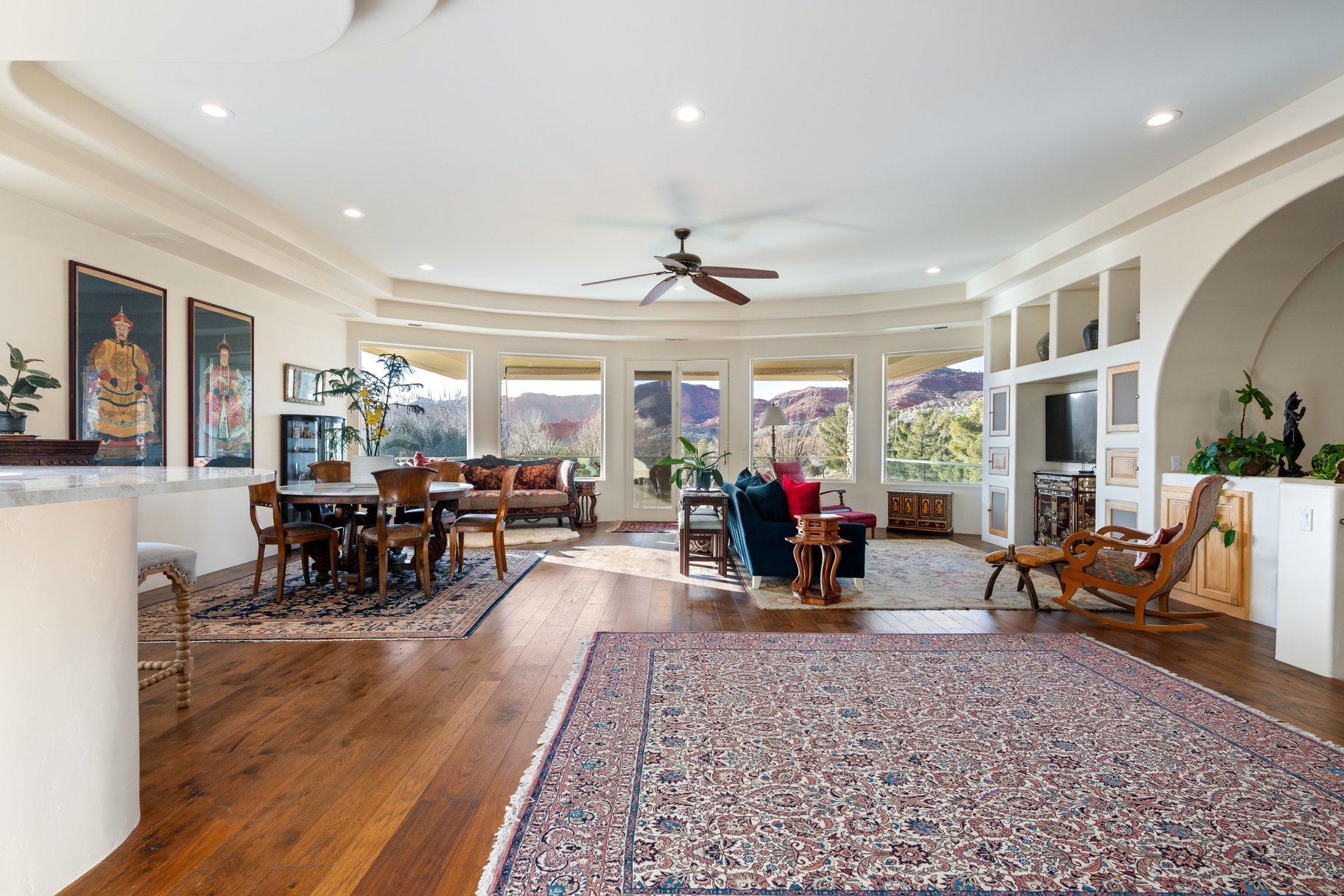Living area with dark wood finished floors, a ceiling fan, a tray ceiling, and recessed lighting