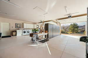 Garage with washer and dryer, a mountain view, and a garage door opener