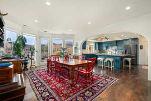 Dining room with arched walkways, ceiling fan, and recessed lighting