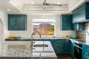 Kitchen with exhaust hood, black oven, ceiling fan, wood tiled floors, and recessed lighting