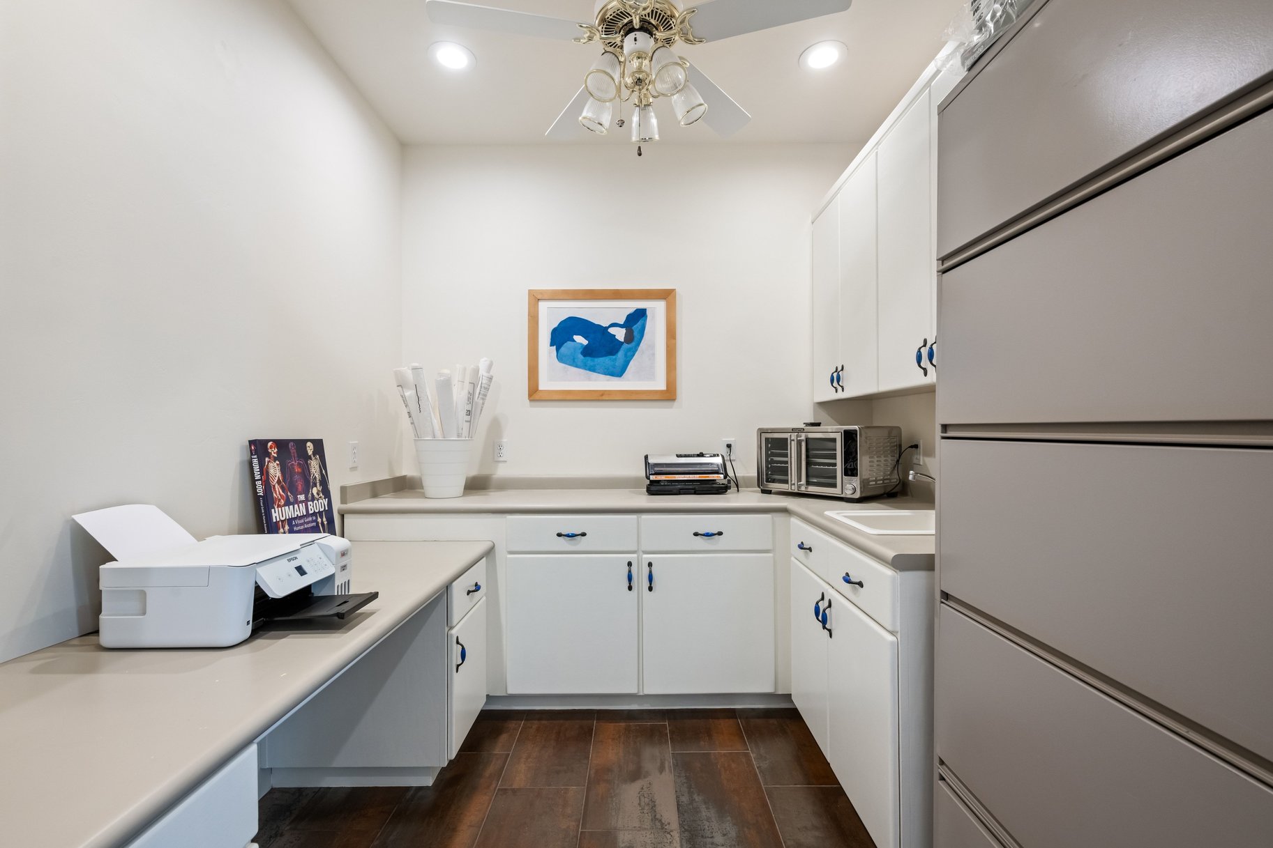 Kitchen with white cabinetry, light countertops, dark wood-style flooring, fridge, and recessed lighting