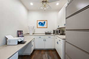 Kitchen with white cabinetry, light countertops, dark wood-style flooring, fridge, and recessed lighting