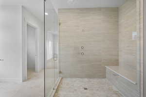 Full bathroom featuring a stall shower and baseboards