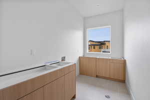 Kitchen with light wood finish cabinetry, modern cabinets, and light tile patterned floors
