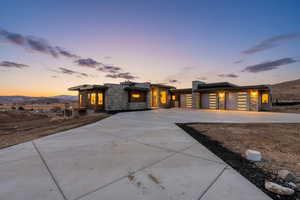Contemporary house featuring stone siding, driveway, and an attached garage