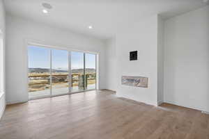 Unfurnished living room featuring a mountain view, light wood finished floors, and recessed lighting