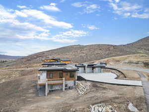 View of front of property featuring a mountain view, roof mounted solar panels, and stone siding
