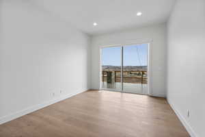 Empty room with light wood finished floors, recessed lighting, and a mountain view