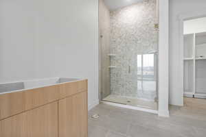 Bathroom with a shower stall and light tile patterned floors