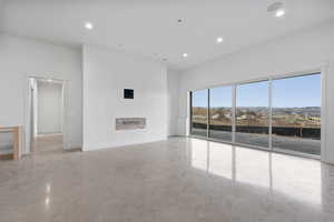 Unfurnished living room with finished concrete flooring, recessed lighting, and a mountain view