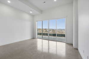 Empty room featuring finished concrete floors, recessed lighting, and a mountain view