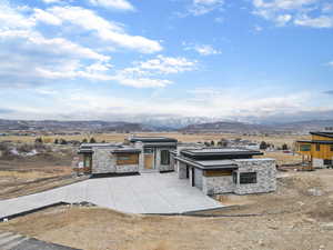View of patio with a mountain view, driveway, and a garage