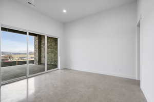 Empty room featuring concrete floors, a mountain view, and recessed lighting
