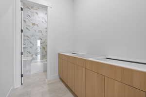 Bathroom featuring washtub / shower combination and double vanity