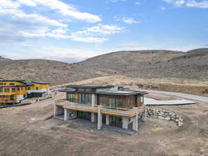Rear view of property featuring stone siding and a mountain view