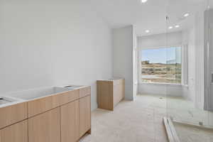 Bathroom with a garden tub, recessed lighting, vanity, and light tile patterned floors