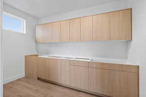 Kitchen with modern cabinets, light wood finish cabinets, and light wood-type flooring