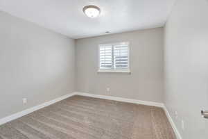 Carpeted spare room with baseboards