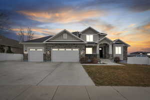 Craftsman-style home featuring board and batten siding, stone siding, concrete driveway, and a garage