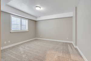 Unfurnished room with light colored carpet and a textured ceiling