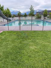 View of pool with a mountain view, a water slide, and patio surround