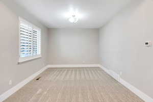Empty room with light carpet and baseboards