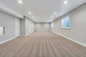 Below grade area featuring light colored carpet and recessed lighting