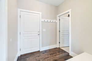 Doorway with wood finished floors and baseboards