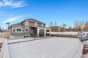 Rear view of property featuring a fenced backyard, a swimming pool, stucco siding, a shingled roof, and a patio area
