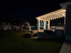 Yard at night featuring a patio area and a yard