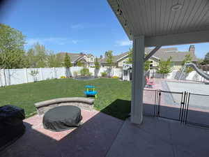 Fenced backyard featuring a patio area, a grill, and a residential view